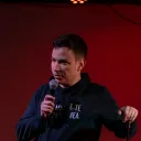 Closeup of Alex talking into a microphone